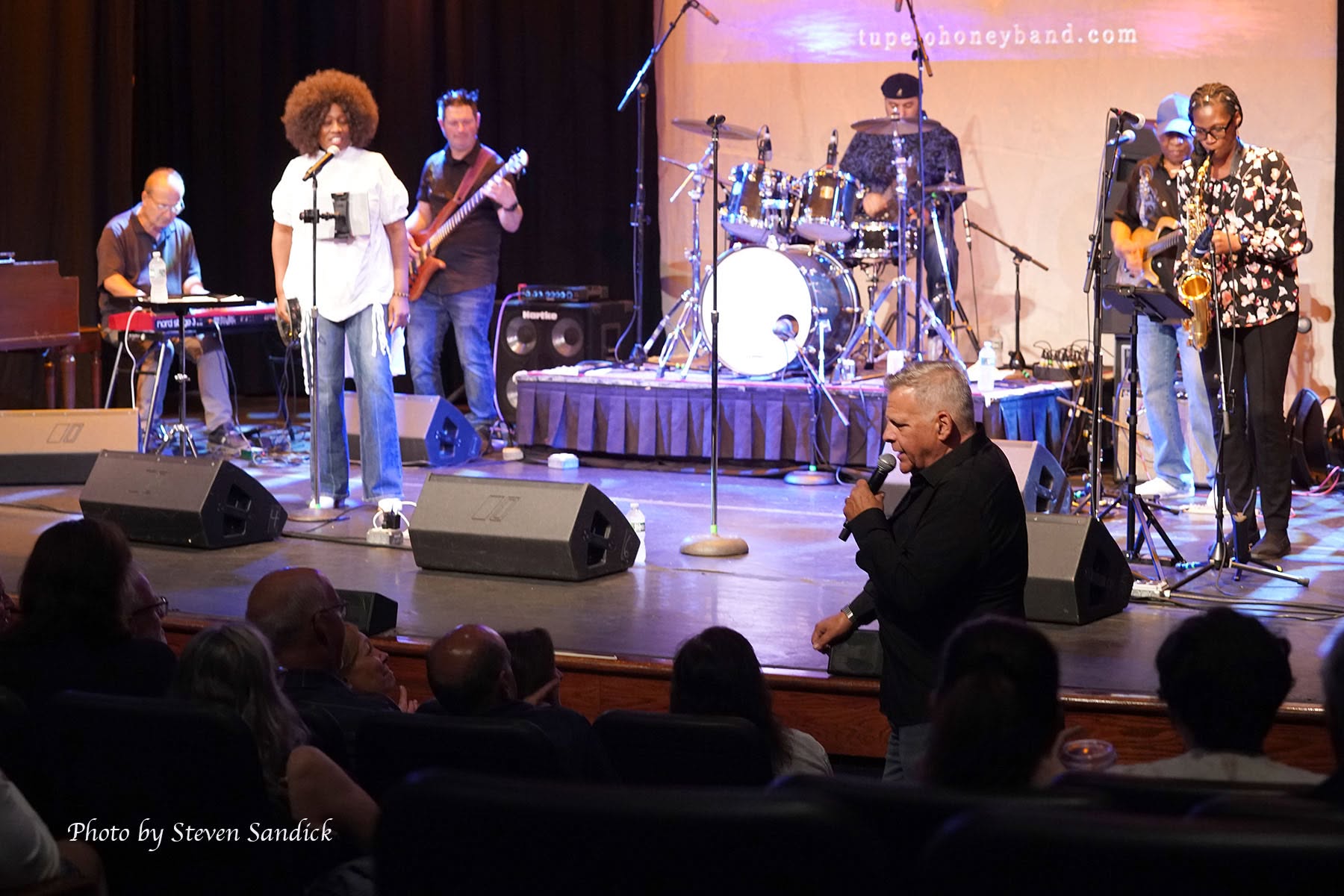 Full band performing at a theater