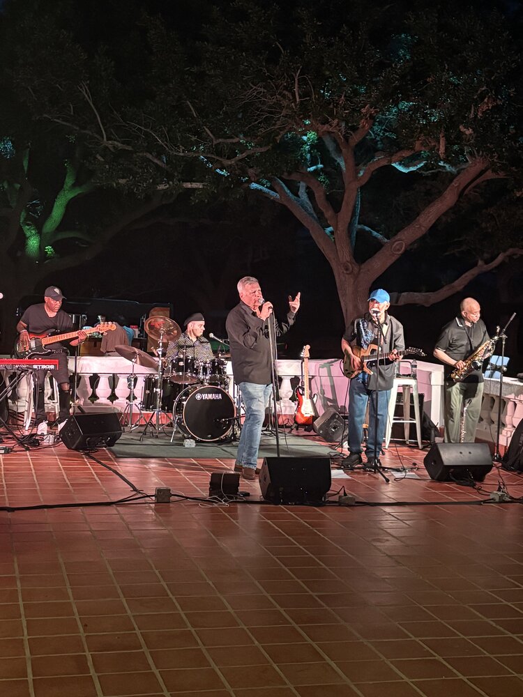 Full band performing at an outdoor evening show